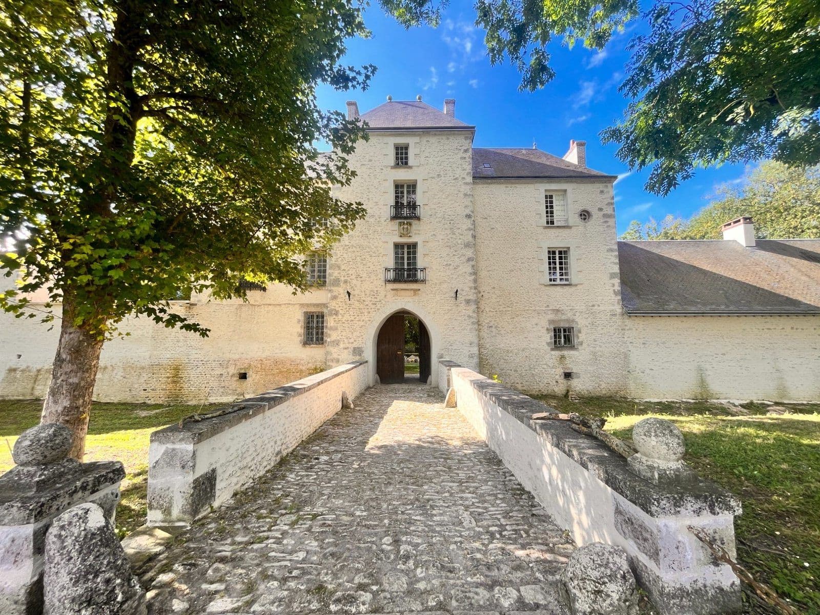 Façade d’un petit château en pierre avec son pont